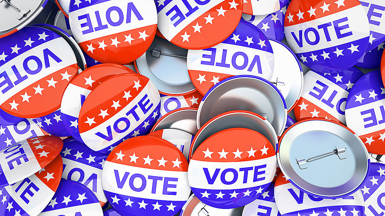 Red, white, and blue "VOTE" buttons with stars scattered in a pile.